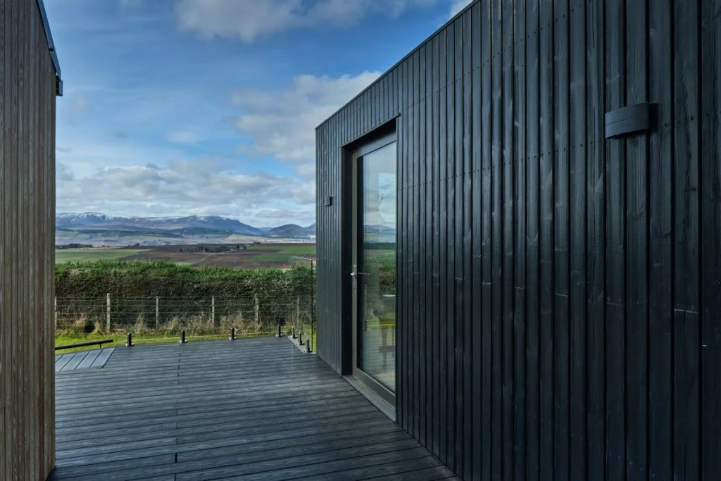 Thermopine black timber cladding in front of a mountain view in Scotland