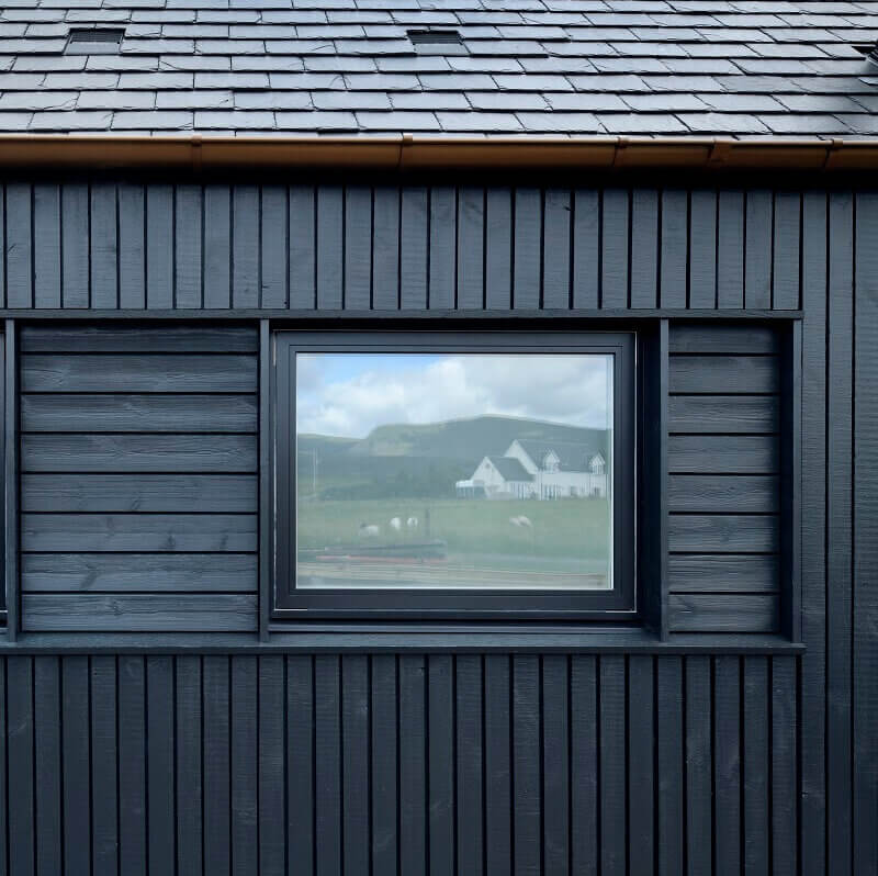 Brushed Thermopine® Cladding in profile RW014 (an open rainscreen timber cladding arrangement) and Thermopine® (73x20mm) coated black.
