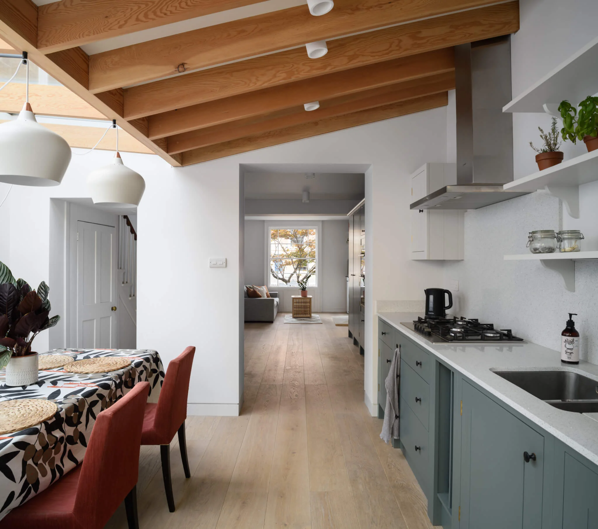 Russwood European Oak Flooring in Pearl in a kitchen with wooden beams on the ceiling and a table with two chairs.