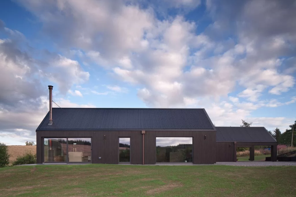 Home clad with Thermopine and a microtex finish factory coated in black paint by Fiddes Architects