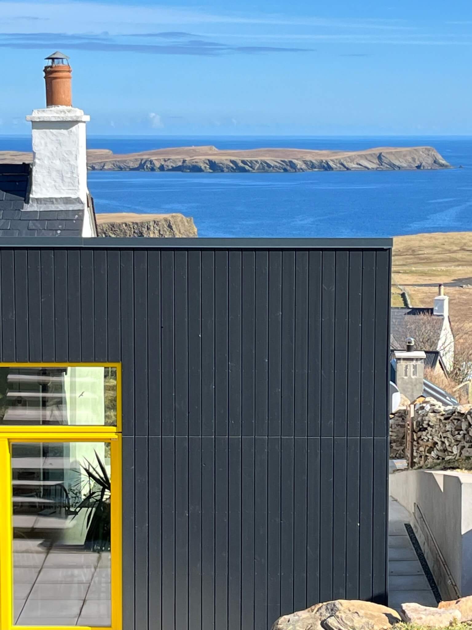 a black and yellow cladding extension in rural Shetland