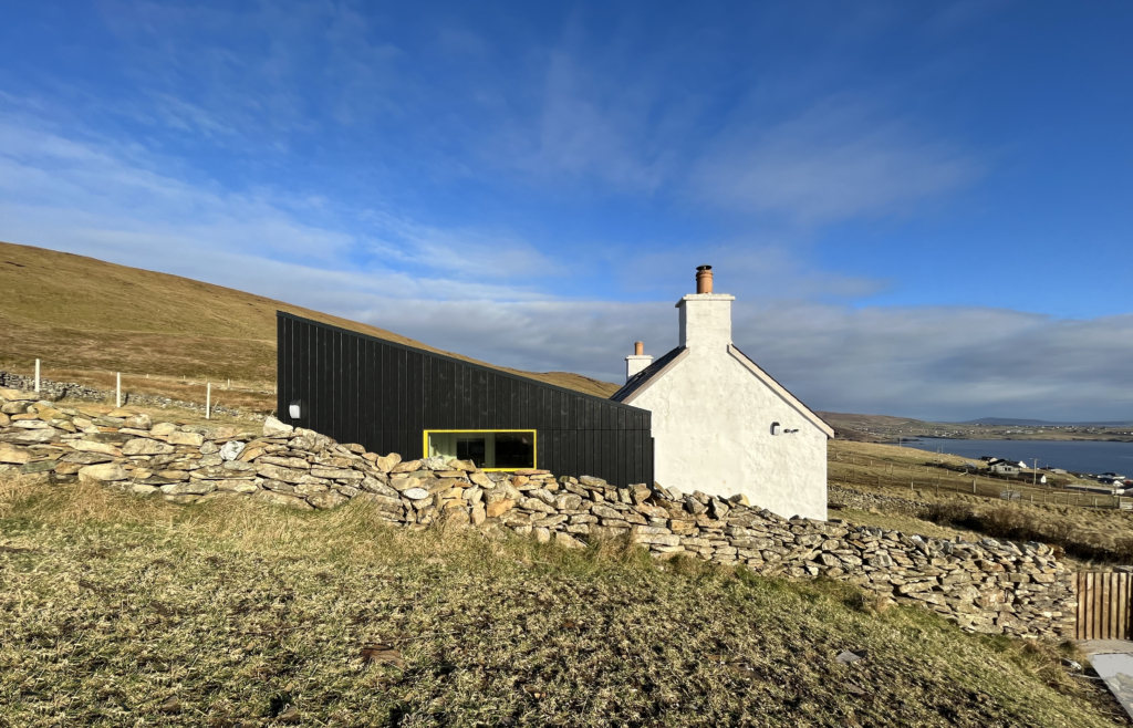 a black and yellow cladding extension in rural Shetland, Burnside Cottage